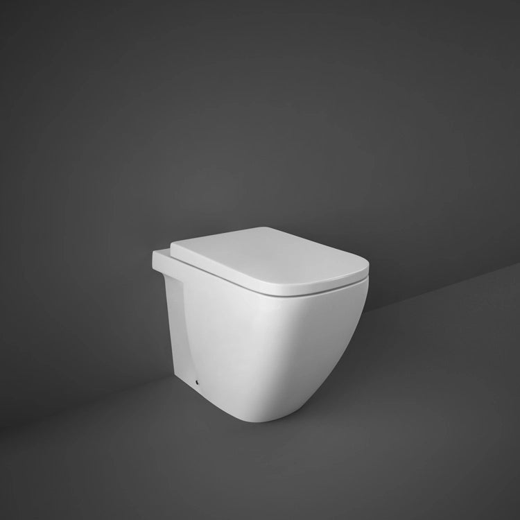 A studio photograph of the RAK-Caroline 55cm Back To Wall water closet pan in Alpine White, showcasing its distinctive rounded-rectangle shape and seamless floor-standing profile.